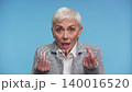 Senior woman asking for money on blue background 140016520