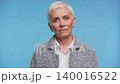 Disapproving senior woman portrait on blue background 140016522