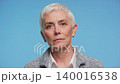 Serious senior woman portrait on blue background 140016538