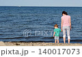 Mom with little child on sea shore 140017073
