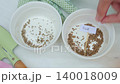Hand places parsley and dill labels into ceramic bowls with seeds. Concept of herb planting and kitchen garden preparation 140018009