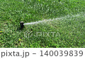 Automatic sprinkler system watering green field with grass or lawn. Irrigation, sprinkler turning and working on summer sunny day, close-up. Parks and back yards maintenance 140039839