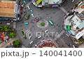 Top-down aerial timelapse of busy roundabout in Ho Chi Minh City, Vietnam, featuring flowing traffic, scooters, cars, public buses, and dynamic urban movement in a vibrant Southeast Asian city. 140041400