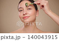 Young beauty woman using a natural jade face roller 140043915