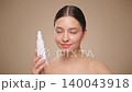 Beautiful woman with bottle of moisturizer cream 140043918