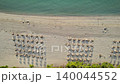 Relaxing beach environment with endless sand calm Mediterranean waters surrounded by comfortable loungers. 140044552