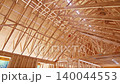Workers are building roof using wooden trusses beams at construction site 140044553