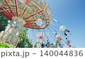 People have fun riding the carousel on a sunny day 140044836