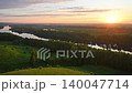 A landscape with a winding river flowing through a dense forest 140047714