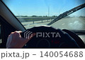 Close-up of hands on the steering wheel of a car while driving on a high-speed road. 140054688
