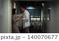 Romantic smiling couple, man and woman standing in hallway and talking, holding glasses of champagne, having fun together, happy friendly husband and wife laughing 140070677