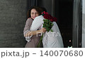 Happy Valentine's Day. A man gives his beloved woman a bouquet of red roses. Husband gives pleasant surprises to his wife 140070680