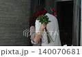 Happy Valentine's Day. A man gives his beloved woman a bouquet of red roses. Husband gives pleasant surprises to his wife 140070681
