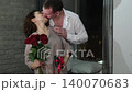 Happy Valentine's Day. A man gives his beloved woman a bouquet of red roses. Husband gives pleasant surprises to his wife 140070683