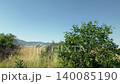 Driving plate distance view of beautiful Besparmak or Girne mountains also known as Kyrenia mountain range in Cyprus. Wide dry yellow summer field landscape. 140085190