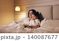 Loving mother reading a book to her little daughter in bed before sleep. A cozy family moment sharing a bedtime story in the evening 140087677