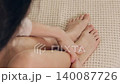 Gentle hands applying soothing massage to tired feet and ankles. A self-care routine for relaxation, pain relief, and wellness at home 140087726