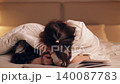 Young mother and her little daughter playfully hiding under a cozy white blanket. Loving family enjoying a tender moment together in the bedroom 140087783