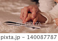 Adult hand guiding a child's finger along the text of a book. Parent teaching a kid to read, showing letters and words on the page 140087787