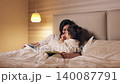 Loving mother reading a fairy tale book to her cute little daughter before sleep. Happy family enjoying a bedtime story together in a cozy bedroom 140087791