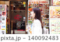 一位微笑的女士悠閒地漫步在唐人街。 140092483