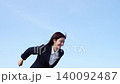 一位穿著西裝的女士欣喜若狂，做出了勝利的手勢。 140092487