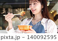 一位女士一邊散步一邊享用美食 140092595