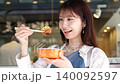 一位女士一邊散步一邊享用美食 140092597