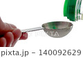 Pour the liquid seasoning into the measuring spoon. 140092629