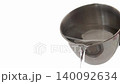 water dripping from a metal cup 140092634
