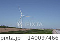 A video showcasing the clean energy of wind turbines on a coastal embankment road, tidal flats, and the blue sky. 140097466