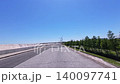 Bicycle POV ride: Action camera video of wind turbines and blue sky on a coastal embankment road. 140097741