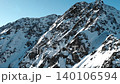 Aerial view of snow covered mountain peaks under a clear blue winter sky . Media 140106594