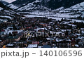 Aerial view of a snowy mountain town at dusk with glowing lights . Media 140106596