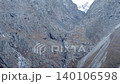 Rugged snowy mountain valley with steep rocky cliffs and dramatic alpine terrain . Media 140106598