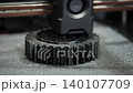 Industrial 3D printer manufacturing a plastic gear component using additive technology. Automated production process for engineering, prototyping and product development. 140107709