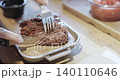 Person is cutting a delicious grilled beef steak with a knife and fork 140110646