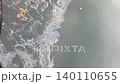 Colorful oil slick creating a rainbow pattern on the polluted water surface 140110655