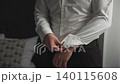 A man buttons the sleeves of his shirt and gets 140115608