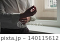 A man buttons the sleeves of his shirt and gets 140115612
