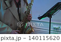 A woman plays the saxophone at a celebration 140115620