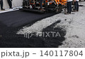 10 December 2025 Chicago IL US. Workers operate machinery to lay down asphalt on road surface in construction site 140117804