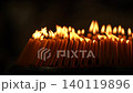 Rows of warm candle flames in a dark temple setting create a sacred visual composition with glowing light, soft smoke, and peaceful Buddhist worship atmosphere. 140119896