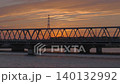 夕日が沈む鉄橋を渡る列車 140132992