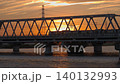 夕日が沈む鉄橋を渡る列車 140132993