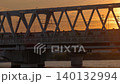 夕日が沈む鉄橋を渡る列車 140132994