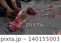 Butcher cuttingButcher cutting raw meat on a wooden chopping block	 raw meat on a wooden chopping block	 140155003