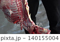 Butcher cuttingButcher cutting raw meat on a wooden chopping block	 raw meat on a wooden chopping block	 140155004