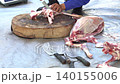 Butcher cuttingButcher cutting raw meat on a wooden chopping block	 raw meat on a wooden chopping block	 140155006
