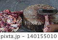Butcher cuttingButcher cutting raw meat on a wooden chopping block	 raw meat on a wooden chopping block	 140155010
